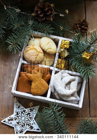 Assorted Christmas Cookies And Christmas Decorations In A Wooden Box On A Wooden Background. Rustic 