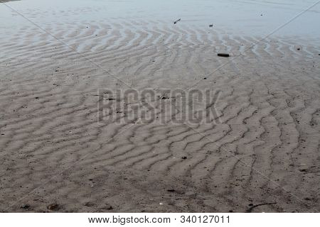 Water And Sand Waves On The Beach