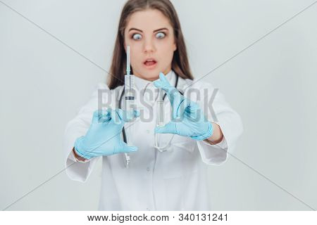 Blurred Strange Female Doctor Holding Her Hands With Syringes In Front Of Camera, Looking Crazily.