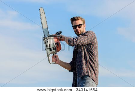 Sharp Blade. Handsome Man With Chainsaw Blue Sky Background. Gardener Lumberjack Equipment. Lumberja