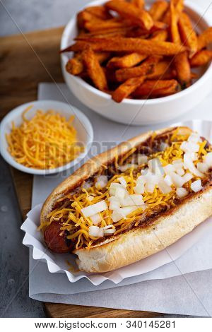 Chili Hot Dog Topped With Cheese And Onion, Served With Sweet Potato Fries