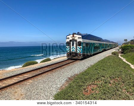 Amtrak Pacific Surfliner Train With Blue Ocean And Blue Sky, Passing By Del Mar, San Diego. Usa. Oct