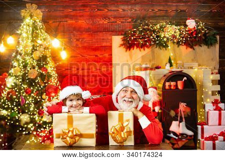 Santa Claus Kid Boy With A Gift Full Of Presents. For Christmas And New Year Posters. Adorable Child