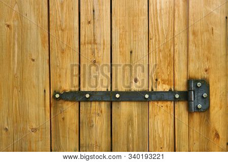 Iron latch and yellow wooden gate closeup on the ranch house for background or texture
