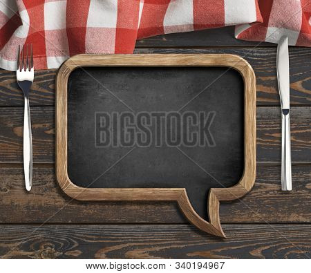 menu blackboard frame on old wooden dinning table with red tablecloth, tableknife and fork