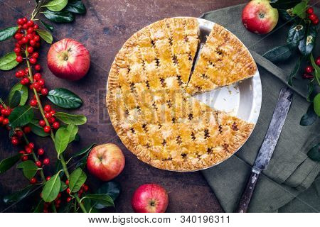 Traditional apple jalousie cake offered as top view in a backing form with decoration on a black board