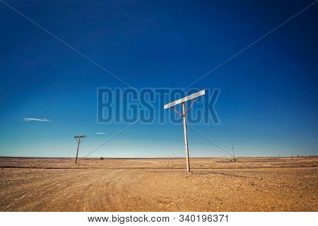 Australia â Old Ghan railway crossing at the outback desert under blue sky 