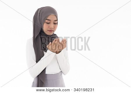 Young Adult Muslim Woman girl making Duas for Muslim god blessing prayer. Studio shot of woman isolated on white background
