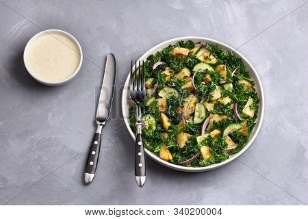 Kale Gabage Salad With Baked Potatoes, Cucumber, Red Onions And Mustard Yogurt Sauce On Gray Texture