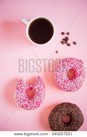 Tasty And Delicious Donuts With Pink Icing And Powder With A Cup Of Aromatic Coffee On A White Woode