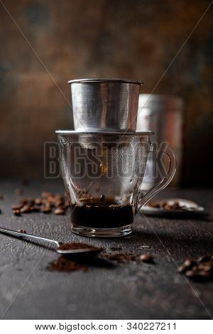 Preparation Of Vietnamese Coffe With Aluminum Cofe Filer On Dark Background