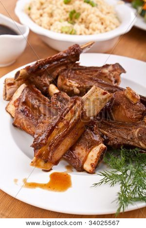 Barbecue spareribs på en tallerken med grøntsager og couscous