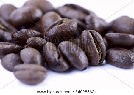 A Group Of Freshly Roasted Coffee Beans On A White Background.close-up, Horizontal, Macro, Place For