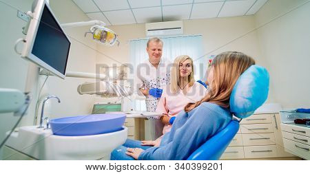 A Team Of Dentists With Client In A Dental Office, Oral Care, Healthy Teeth, Stomatology Concept.