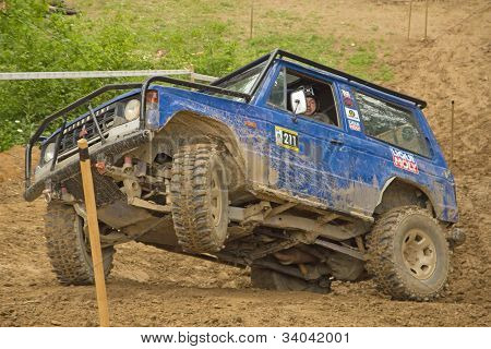 Blå bil på en stejl skråning i terrænet