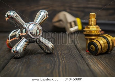 Cruciform Hot And Cold Water Main Switch Of Spare Parts On Black Wooden Boards