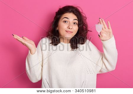 Picture Of Young Brunette Woman With Wavy Hair Holding Menstrual Cup And Squeesing Her Shoulders, Do