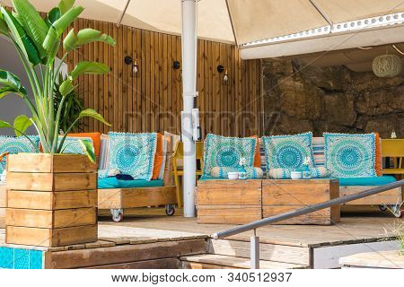 Cafe On The Open Air. Chairs, Sofa And Tables Outside On The Summer Sun Weather In Spain. Design Of 