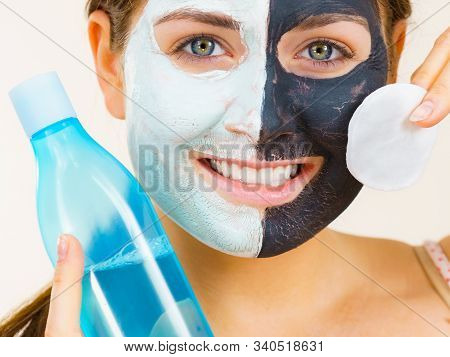 Woman With Clay Carbo Black Mask On One Half Face And White Mud On Second Half. Girl Removing Cosmet