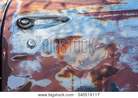 A Very Rusted Door Of An Old Abandoned Car.