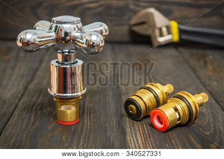 Cruciform Hot And Cold Water Main Switch Of Spare Parts On Black Wooden Boards