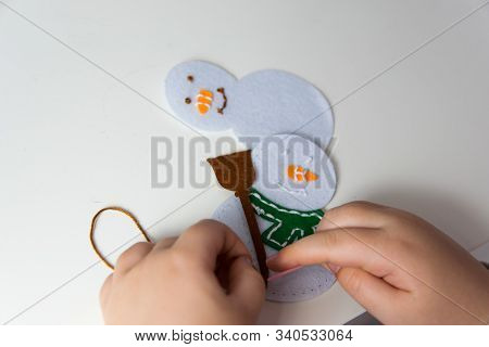 The Hand Of The Child Make Snowman For Christmas Greeting Card. Hobby Concept. Handmade.