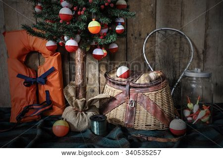 Christmas tree hung with brightly colored fishing bobbers with a basket creel, fishing net, and life jacket