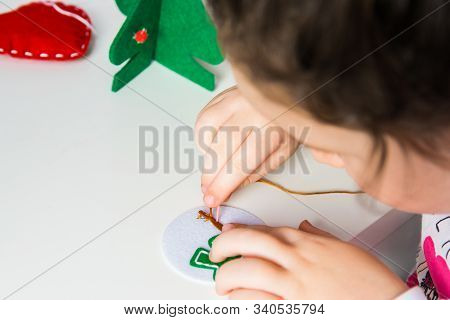 The Hand Of The Child Make Snowman With Needle And Thread For Christmas Greeting Card. Hobby Concept