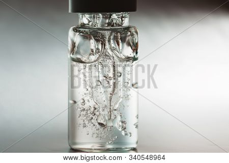 Bottle Of Hyaluronic Acid With Pipette On Silver Background. Front View.