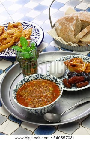 moroccan ramadan iftar meal, harira soup, chebakia, dates, mint tea and khubz