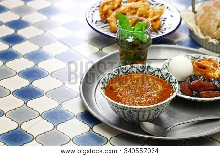 moroccan ramadan iftar meal, harira soup, chebakia, dates, mint tea and khubz