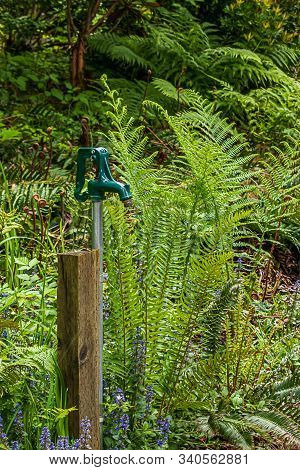 Old Water Pump Attatched To A Wooden Post