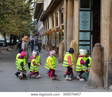 Prague, Czech - Oct 26, 2018. Small Pupils In Reflective Vest Cross The Road At Old Town In Prague, 