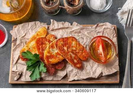Sliced ​​halumi Cheese With Spices. On A Wooden Board. Decorated With Spices And Parsley. Next To Th