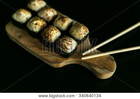 Rolls On A Wooden Board And A Black Table With Sticks. The View From The Top