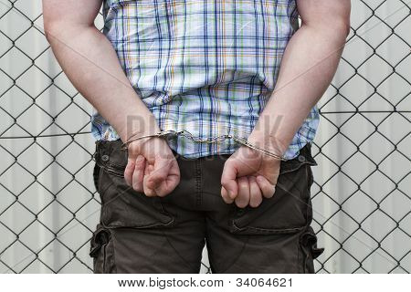 Uomo in manette dietro wire fence