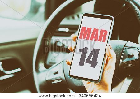 March 14th. Day 14 Of Month, Calendar Date. Month And Day Placed On A Smartphone Screen In Womans Ha