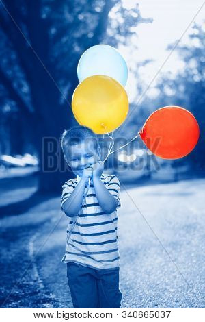 Caucasian Boy Toddler Child With Colorful Balloons In Park Outdoor. Kid Enjoying Playing. Happy Birt