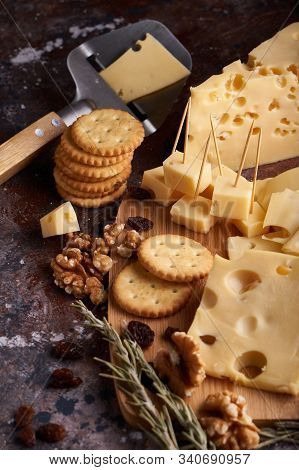 Pieces Of Cheese, Nuts, Raisins, Snacks For Wine On A Wooden Background. Appetitive Copy Space