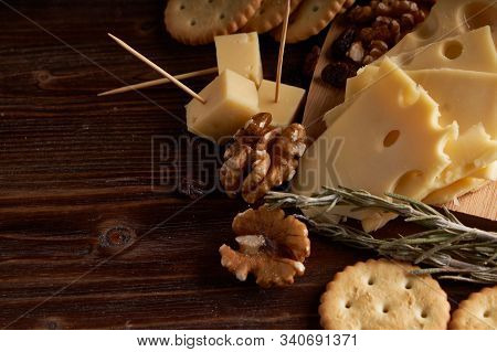 Pieces Of Cheese, Nuts, Raisins, Snacks For Wine On A Wooden Background. Appetitive
