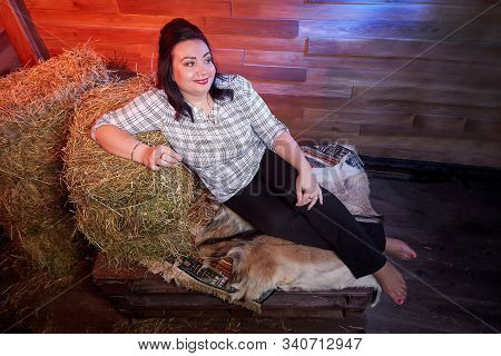 Portrait Of Fat Plump Fun Charming Cute Woman With Black Hair In The Room With Hay And Straw