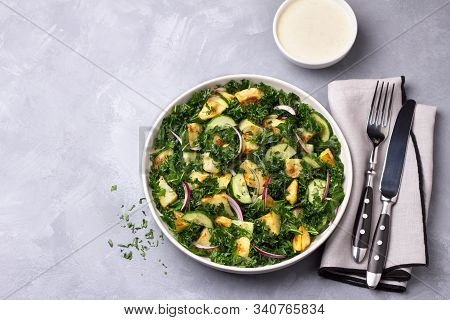Kale Gabage Salad With Baked Potatoes, Cucumber, Red Onions And Mustard Yogurt Sauce On Gray Texture