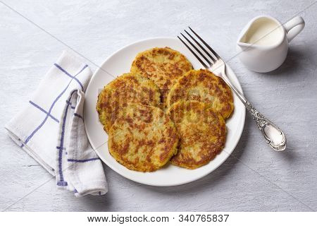 Traditional Latkes Fritters With Sour Cream On A Light Gray Textured Background, Top View