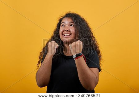 Happy Afro-american Young Woman With Overweight Keeping Fists Up, Doing Winner Gesture Over Isolated
