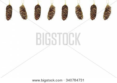 Hanging Pattern Of Eight Gold Coloured Fir Cones Isolated On White Background. Greeting Card. New Ye