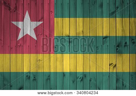 Togo Flag Depicted In Bright Paint Colors On Old Wooden Wall. Textured Banner On Rough Background