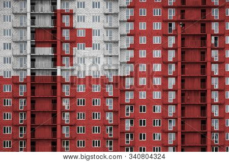 Tonga Flag Depicted In Paint Colors On Multi-storey Residental Building Under Construction. Textured