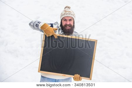 Look Here. Bearded Man In Warm Clothes. Happy New Year. Happy Hipster With Blackboard. Man Advertisi