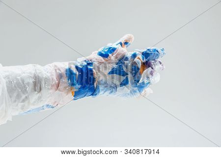 Big Plastic Hand Made Of Garbage Isolated On White Studio Background. The Result Of Polymers Overusi