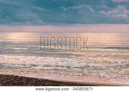 Calm Sea Waves Against A Dark And Stormy Sky